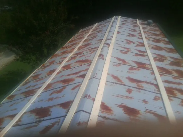 Rusted metal roof panels with new wood purlins before replacement — Storm Damage Roof Repair in Ronan by Roofing Brothers