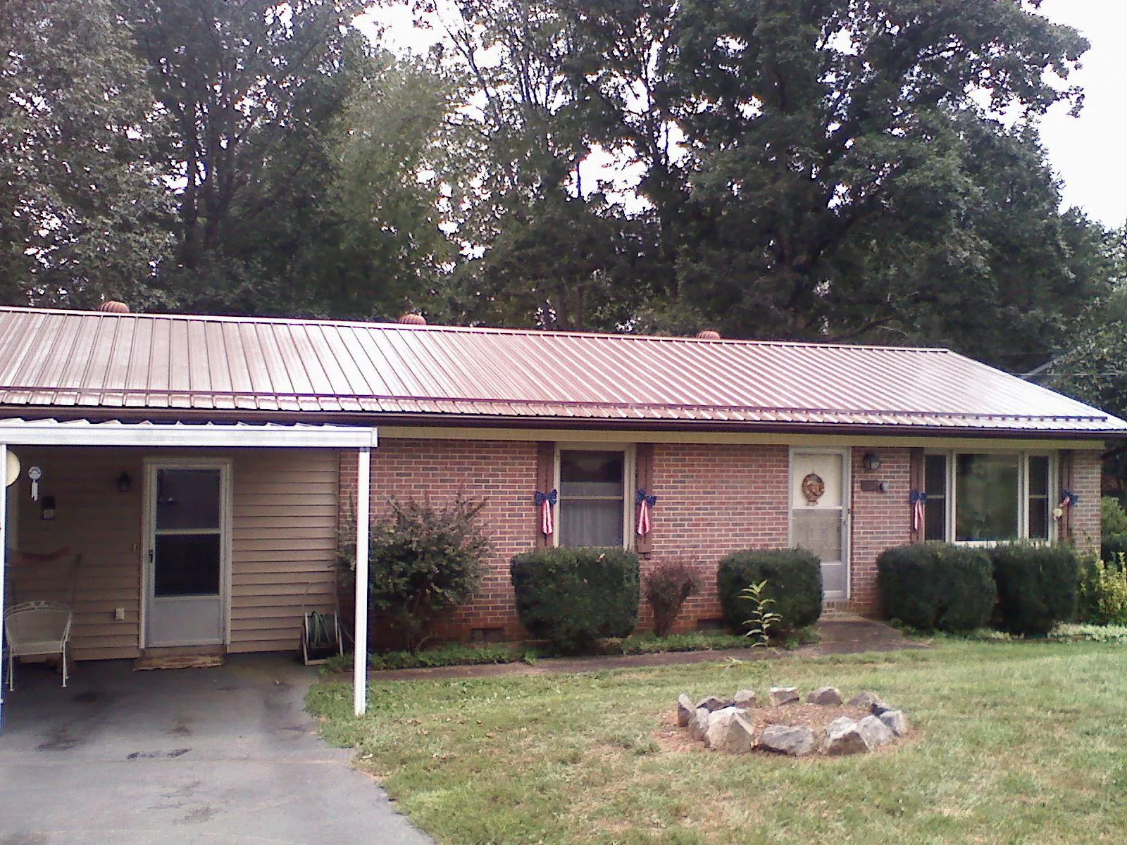 Bronze metal roof and carport on a brick ranch home — Roof Repair work by our crew in Ronan